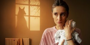 A vibrant theatre exterior with bright lights, showcasing a marquee and a bustling crowd in evening attire.