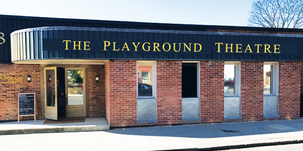 A vibrant playground with colourful equipment, children playing, and trees in the background.