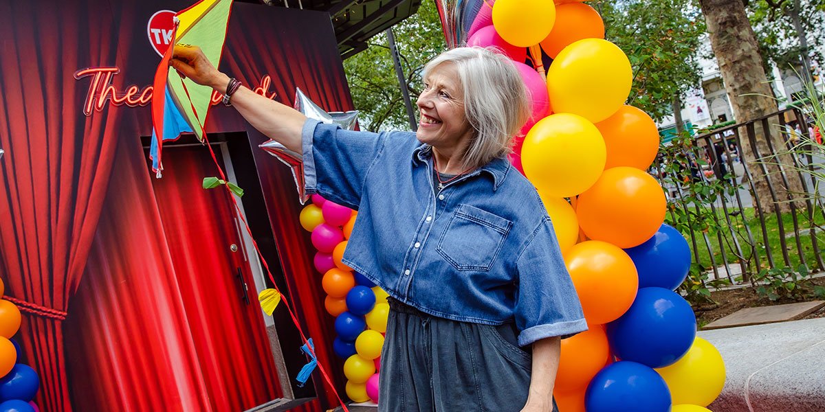 A person holds a kite up into the air
