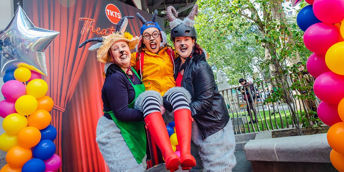 Three people dressed as goats, one being lifted in the centre