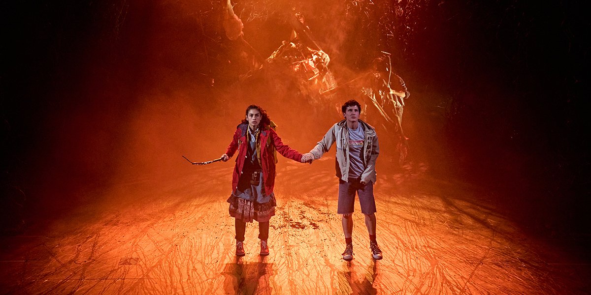 Nia Towle, Lettie, and James Bamford stand together, surrounded by a dark, atmospheric stage backdrop.