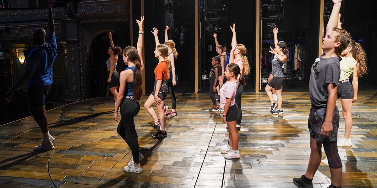 Children learning dance with cast of Tina The Tina Turner Musical
