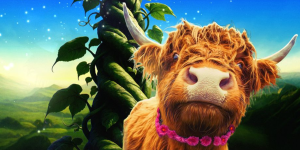 A long haired, brown cow can be seen standing in front of a tall, green beanstalk against a a blue sky.